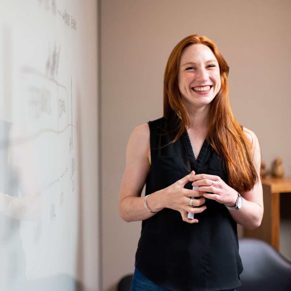 Smiling teacher beside a white board