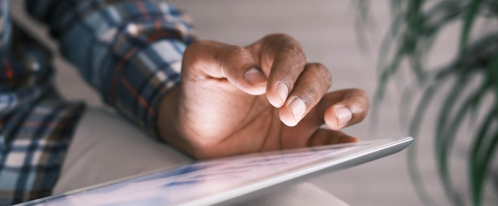 Zoom in on a man's hand holding a tablet